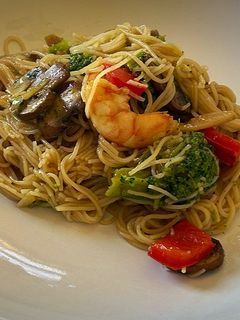 Una foto de Noodles con brócoli, setas y langostinos