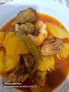 Una foto de Costillas de cerdo con sepia, patatas y langostineras