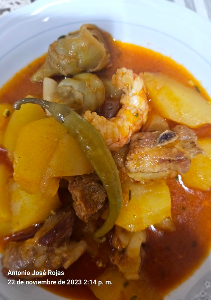 Una foto de Costillas de cerdo con sepia, patatas y langostineras
