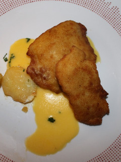 Una foto de Filetes de pollo a la Villaroy de salsa Velouté, con guarnición de abanico de patata, relleno de rulo de cabra, sobre cama de salsa Holandesa