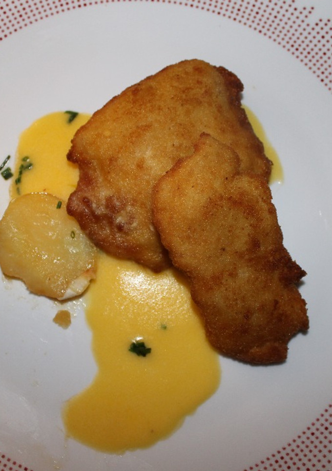 Una foto de Filetes de pollo a la Villaroy de salsa Velouté, con guarnición de abanico de patata, relleno de rulo de cabra, sobre cama de salsa Holandesa
