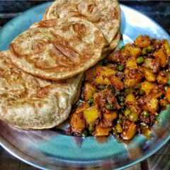 A picture of Aloo Matar Ki Sabzi With Poori.