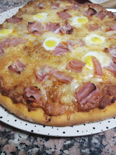 Una foto de Pizza de masa gruesa con huevos de codorniz