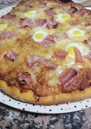 Una foto de Pizza de masa gruesa con huevos de codorniz