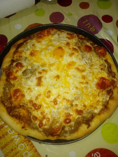 Una foto de Pizza con rulo de cabra y atún en la piedra