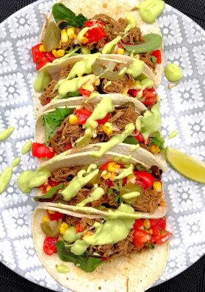 A picture of Pulled goose tacos with avocado sauce.