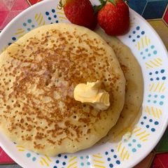 A picture of Original fluffy pancake with honey, butter and strawberry.