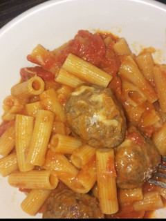 A picture of Penne pasta in tomato meatball sauce.