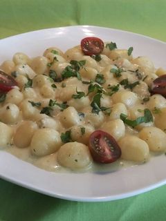 Una foto de Ñoquis al roquefort con albahaca