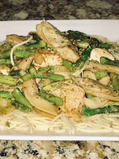 A picture of Jerusalem chicken, grilled artichoke hearts, Asparagus on top of angel hair pasta.