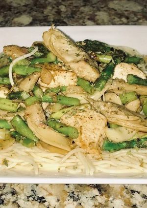 A picture of Jerusalem chicken, grilled artichoke hearts, Asparagus on top of angel hair pasta.