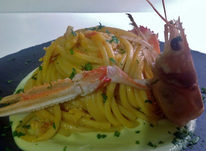 Foto di Spaghetti chitarra con scampi, gamberi e frullato di datterini, su crema di zucchine