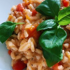 A picture of Risotto with tomatoes, carrots and oranges 🍊.