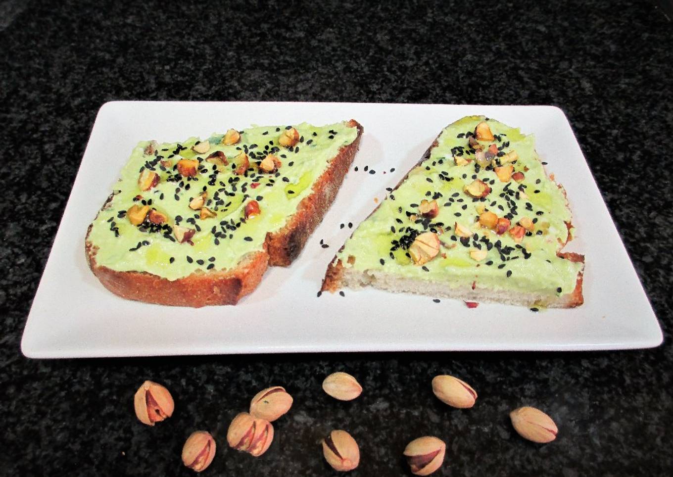 Rebana de pan rústico con paté de aguacate y pistachos