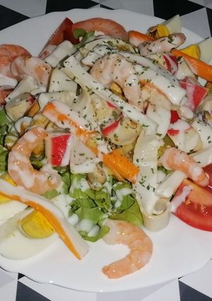 Una foto de Ensalada templada de salpicón de marisco con salsa de yogur