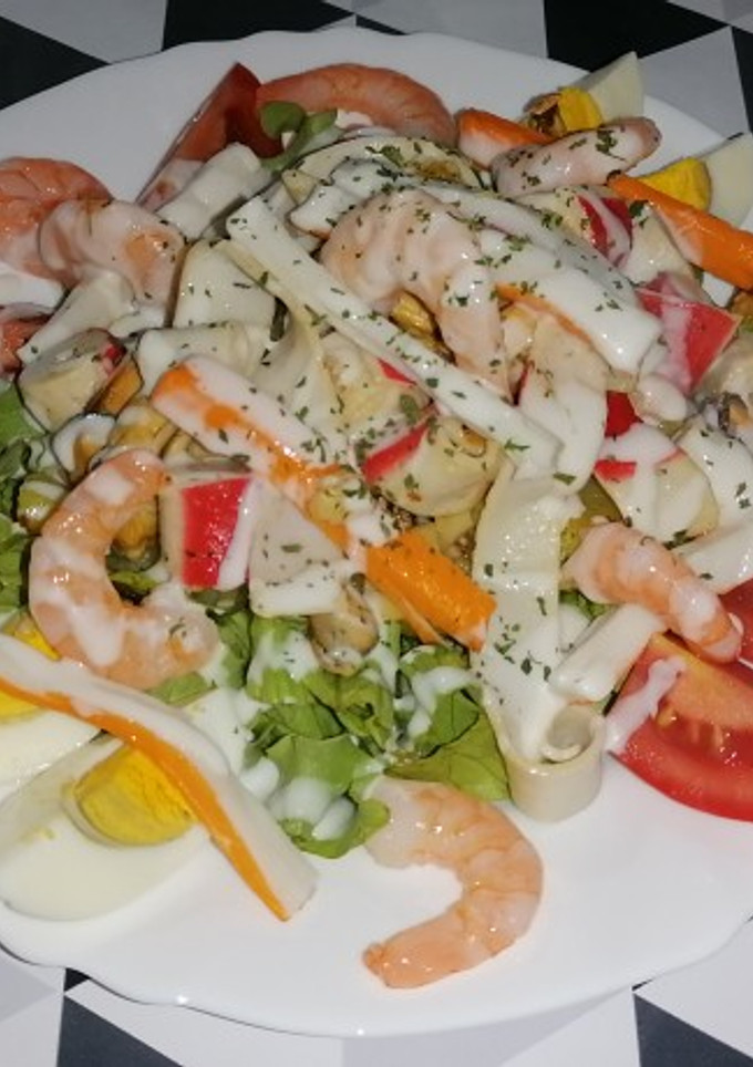 Una foto de Ensalada templada de salpicón de marisco con salsa de yogur