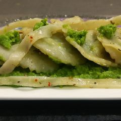 A picture of Spinich, paneer,stuffed ravioli in Green peas creamy sauce.