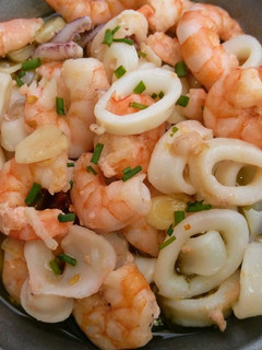 Una foto de Calamares y langostinos al ajillo