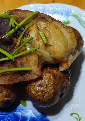 Una foto de Pollo de mar a la bolsa sobre papas rústicas enteras y cilantro