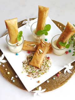 A picture of Moong Dal Halwa Cigars dipped in Shaahi Rabdi.