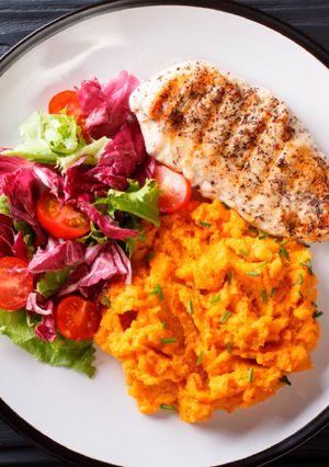 Una foto de Pechuga de pollo con puré de auyama y ensalada