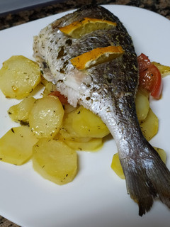 Una foto de Dorada decapitada al horno con patatas y tomate