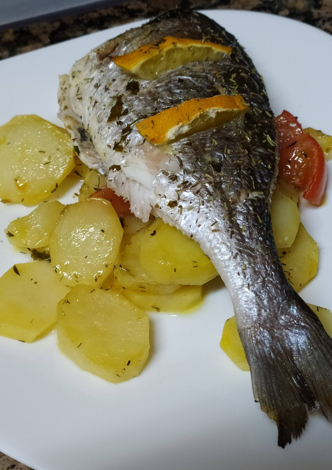 Una foto de Dorada decapitada al horno con patatas y tomate