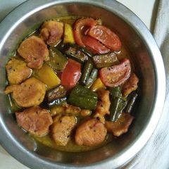 A picture of Tomato lentil fritters curry.