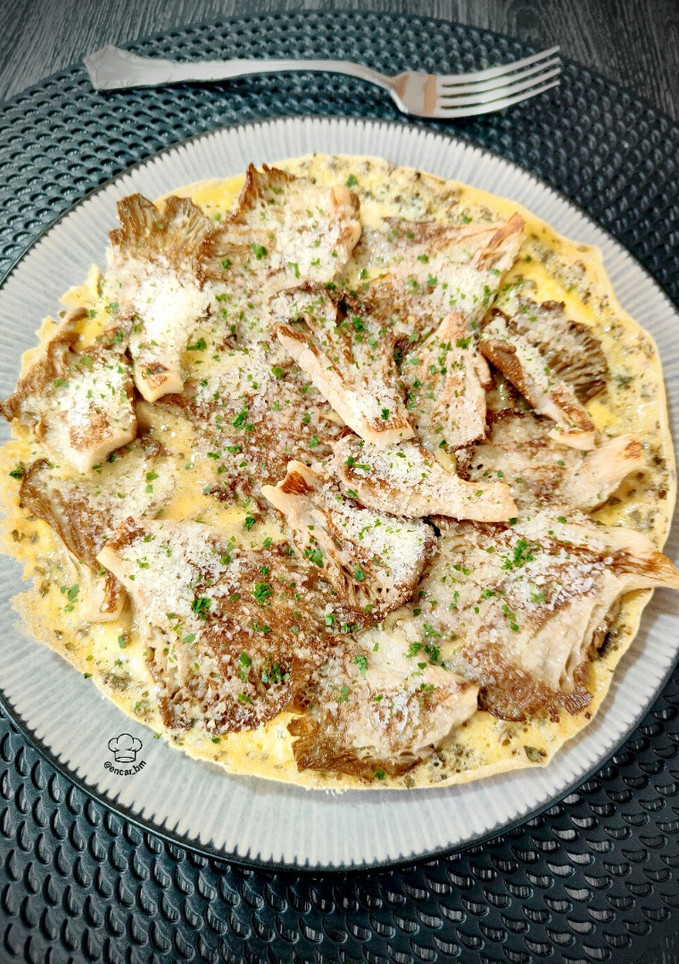 Una foto de Tortilla abierta con setas y parmesano