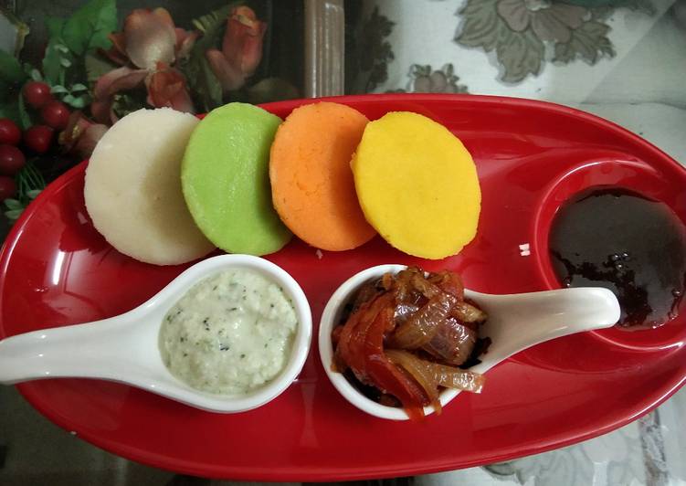 Colourful Idli with spicy onion tomato masala mixture. with coconut and tamarind chutney