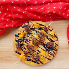 A picture of Chocolate cake and fruit skewer.
