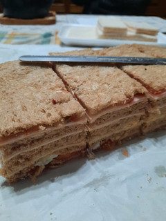 Una foto de Sandwichs de miga con pan negro de jamón,  queso y algo más