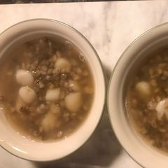 A picture of Sticky rice ball in sweet mung bean & barley soup.