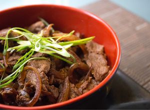 Una foto de Gyudon: fetas de carne salteadas con cebolla sobre un colchón de arroz