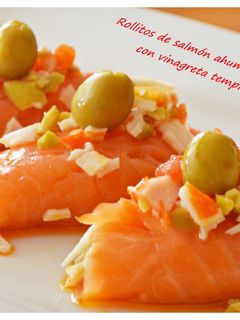 Una foto de Rollitos de salmón ahumado rellenos de gulas y vinagreta templada de tomate