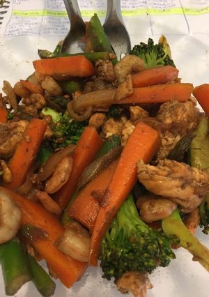 Una foto de Wok de verduras con salmón y camarones