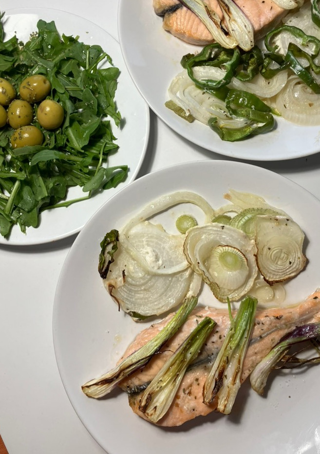 Una foto de Salmón y cebollas en airfryer, con ensaladita de rúcula