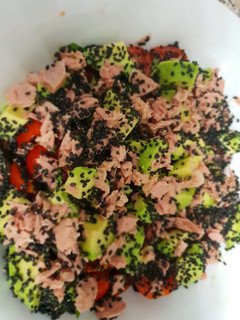 Una foto de Ensalada de tomates cherry y aguacates con semillas de sésamo negro y albahaca