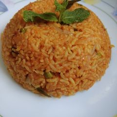 A picture of Tomato rice with peas.