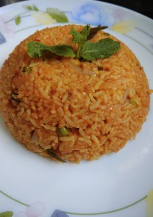 A picture of Tomato rice with peas.
