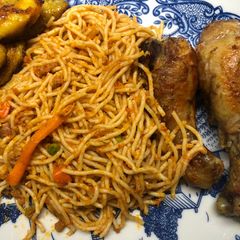 A picture of Jollof spaghetti with mince meat and hotdog.