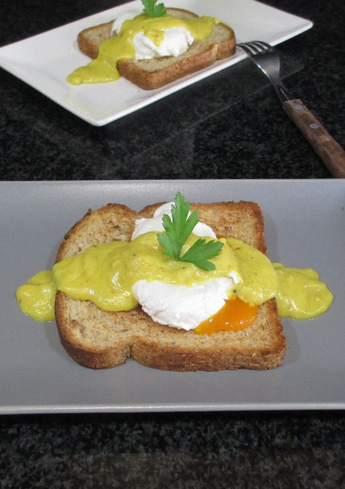 Una foto de Huevos pasados por agua sobre pan de molde bañados con bechamel al curry