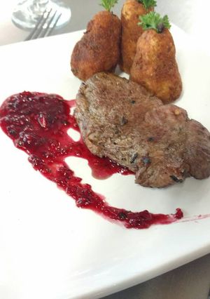 Una foto de Bola de res con salsa de frambuesas y papas williams