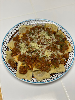 A picture of Ravioli w/ Meat Sauce.
