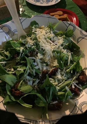 Una foto de Ensalada de rúcula, parmesano y tomates secos
