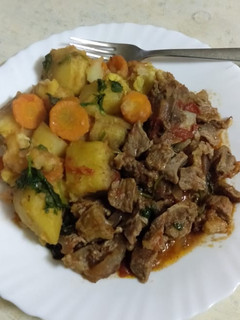 A picture of Beef stew, with matoke.