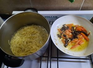 Una foto de Fideos, hongos de pino, tomate y algo más