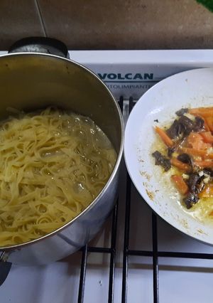Una foto de Fideos, hongos de pino, tomate y algo más