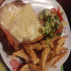 Una foto de Milanesa napolitana con fritas y ensalada