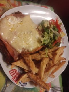 Una foto de Milanesa napolitana con fritas y ensalada
